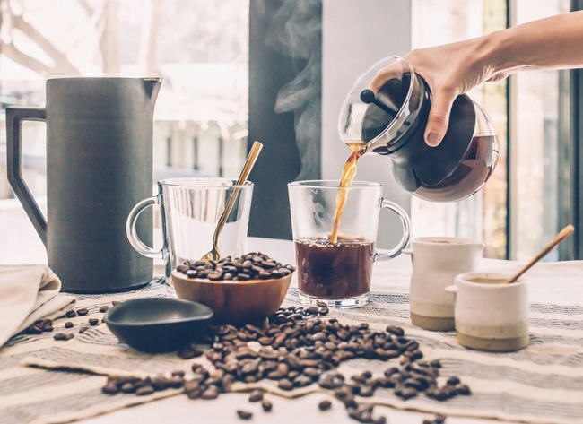 Making French press coffee by pressing the plunger down slowly