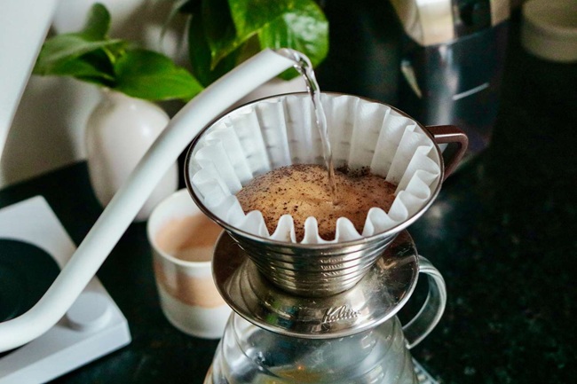 Making pour-over coffee by pouring hot water in slow circles over the grounds